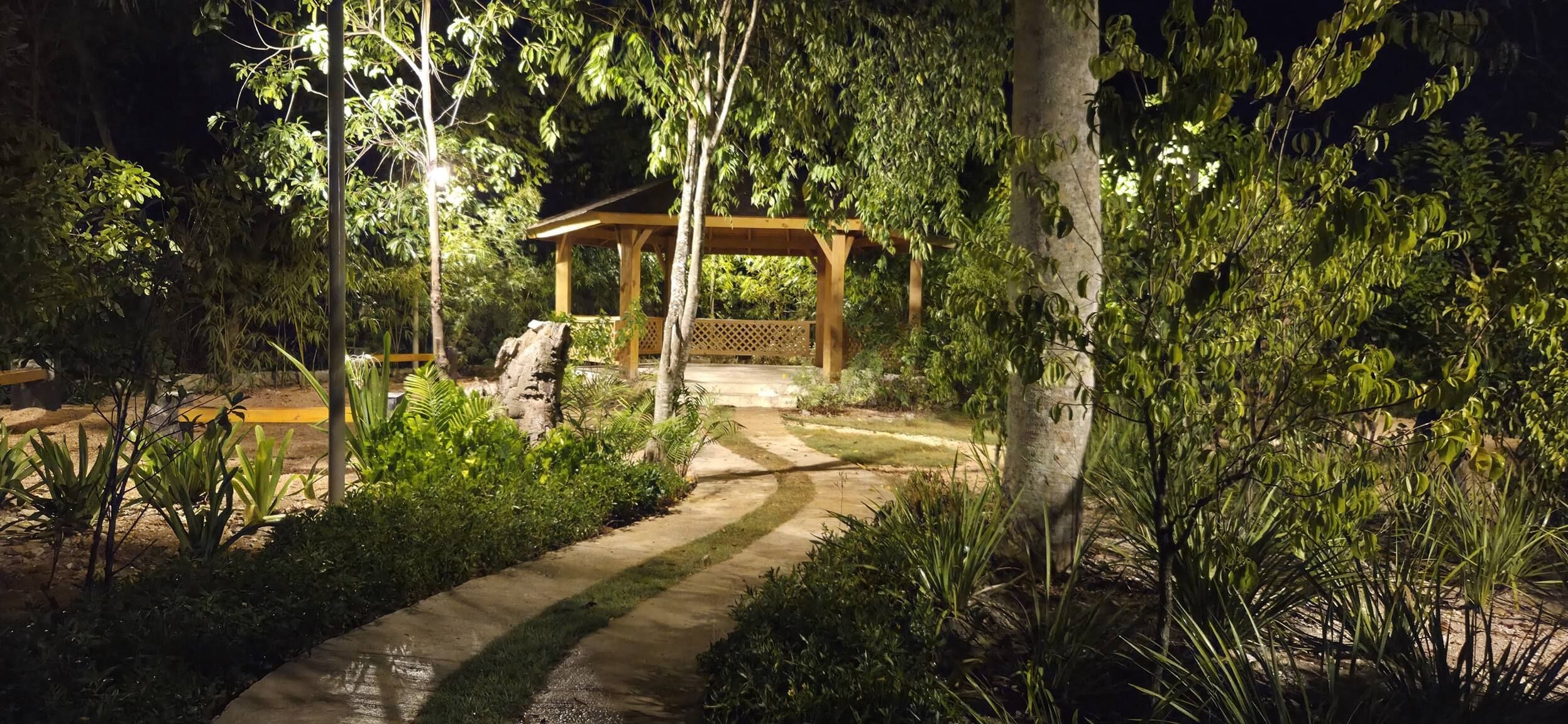 Un sentier de jardin menant à un belvédère en bois.