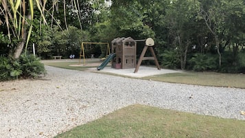 A playground with a slide, climbing structures, and a swing set.