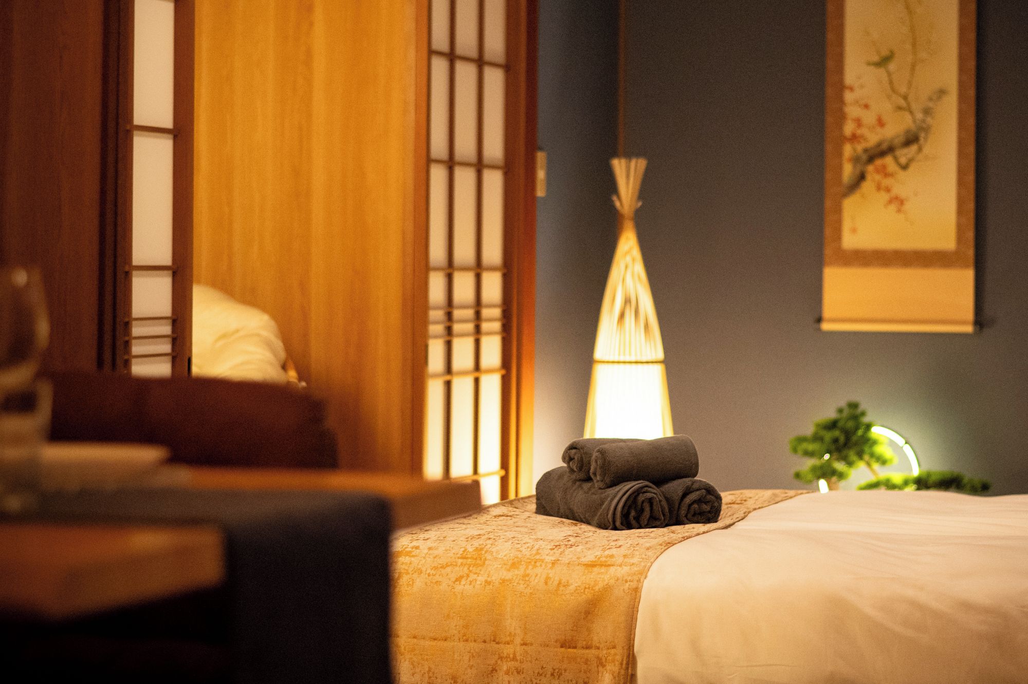 A hotel room with a bed, a lamp, and a window with a view.