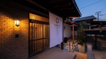 A building with a brick facade, a wooden entrance, and a sign that reads 'ZEROICHI HOUSE HAKATA'.