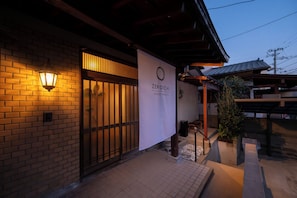 A building with a brick facade, a wooden entrance, and a sign that reads 'ZEROICHI HOUSE HAKATA'. - Zeroichi Hotel House Hakata (Fukuoka)