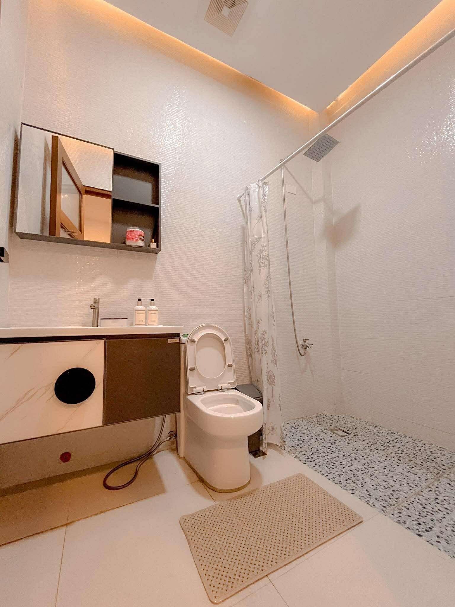 A modern bathroom with a toilet, sink, and shower.