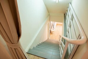 A staircase with a handrail and a door at the top. - Lumi Minimal Residence (Krung Thep Maha Nakhon)