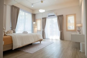 Habitación de hotel con cama, escritorio y ventana con cortinas.
