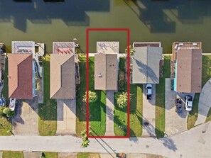 An aerial view of a residential area with houses, a sidewalk, and a body of water. - Garnele's retreat- come relax (Galveston)