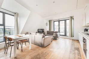 A modern living room with a dining table, sofa, and TV. - Bethnal Green Penthouse & Terrace (London)