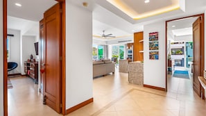 A spacious living area with a large sofa, a dining table, and a kitchen in the background.