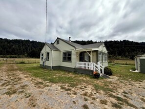 Uma casa de dois andares com varanda e uma pequena escadaria.