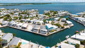 A marina with multiple docked boats, a variety of residential buildings, and a clear view of the surrounding water.