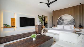 A modern hotel room with a large bed, a flat-screen TV, a ceiling fan, and a view of the outdoors.