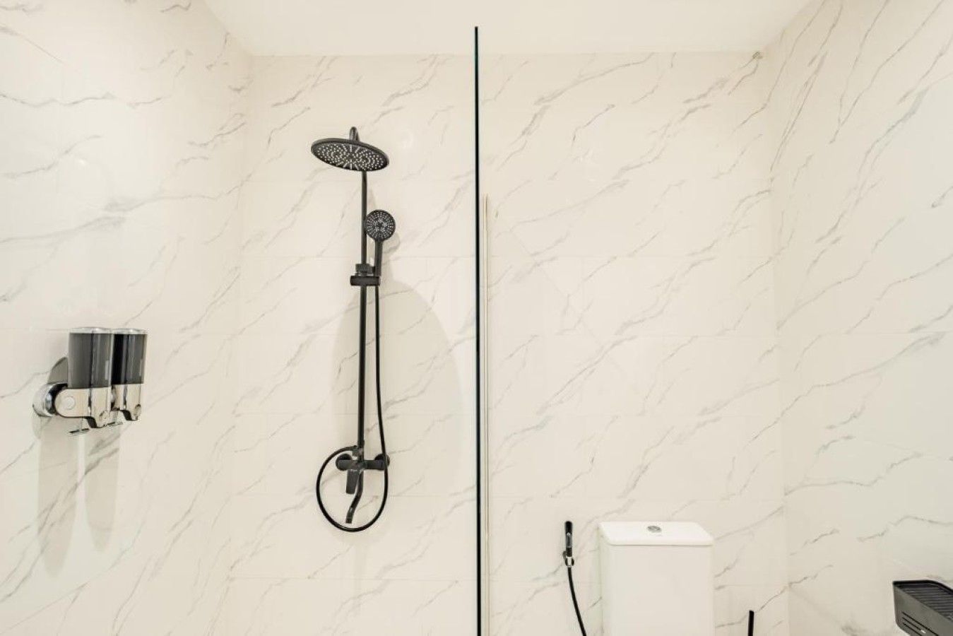 A modern bathroom with a shower, a towel rack, and a toilet.