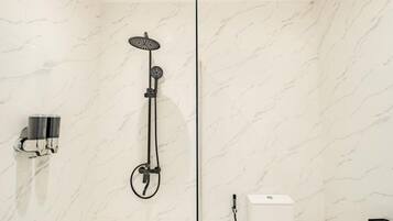 A modern bathroom with a shower, a towel rack, and a toilet.