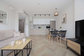 Ein modernes Wohnzimmer mit einer Couch, einem Couchtisch und einem Essbereich mit Stühlen und einem Tisch.