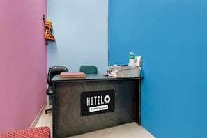 Taulell de recepció d'hotel amb un senyal que indica que ofereix serveis de OYO.
