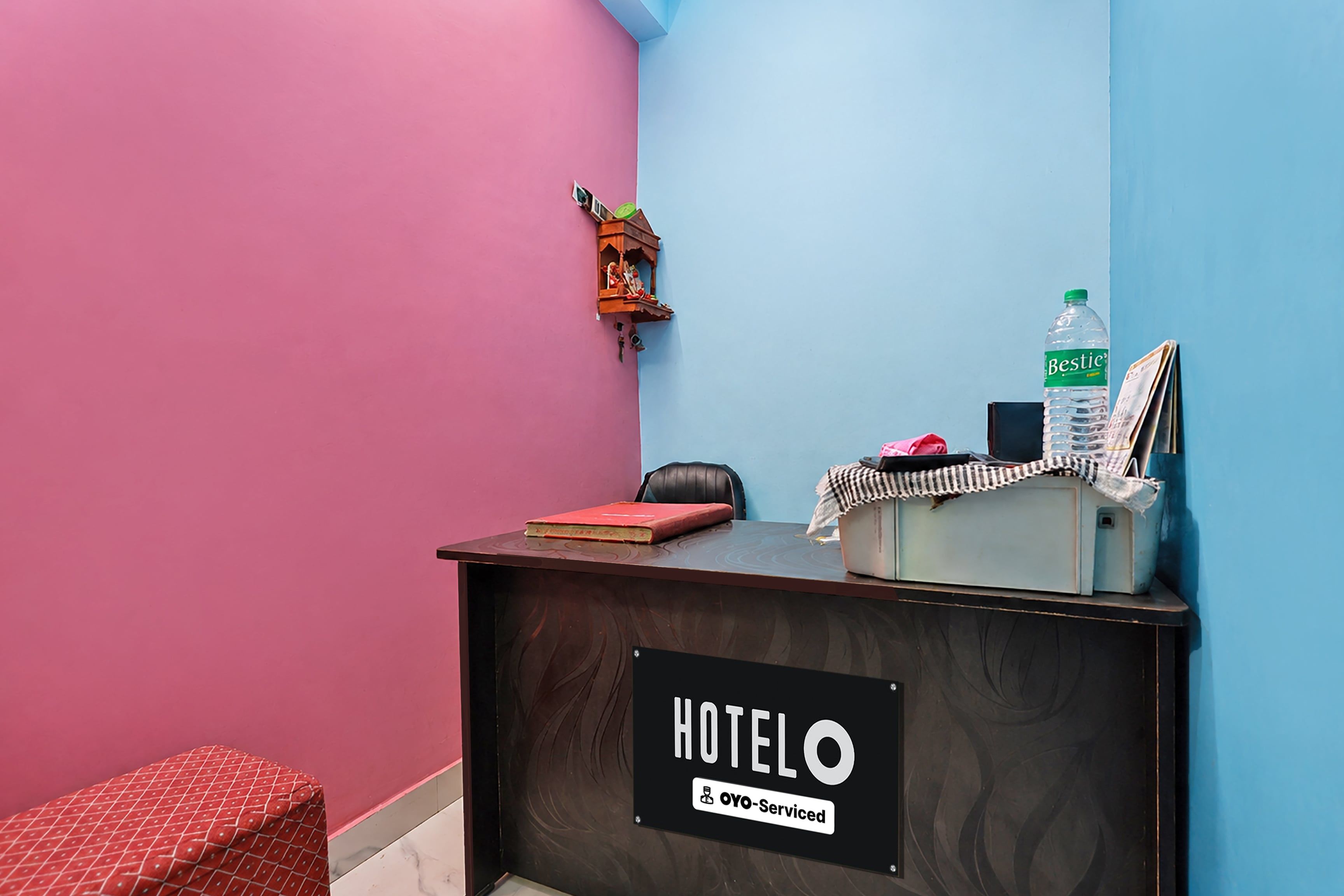 A hotel reception desk with a sign indicating it is serviced by OYO.