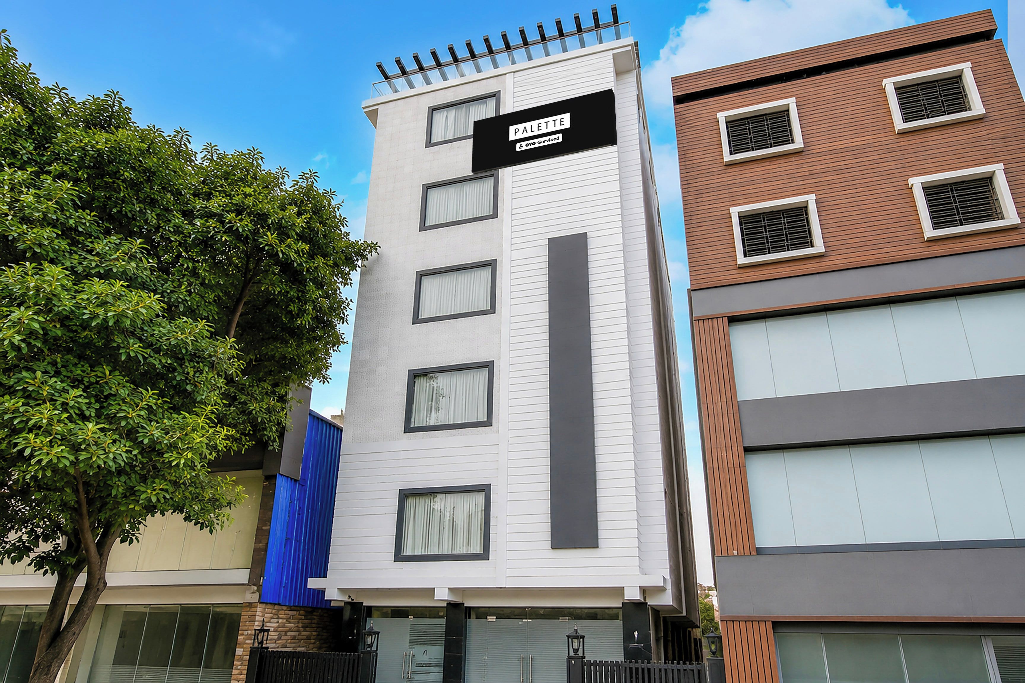 A multi-story building with a sign indicating it is serviced by OYO.