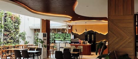 Un intérieur moderne avec un plafond incurvé, un espace bar et différents types d’assises.