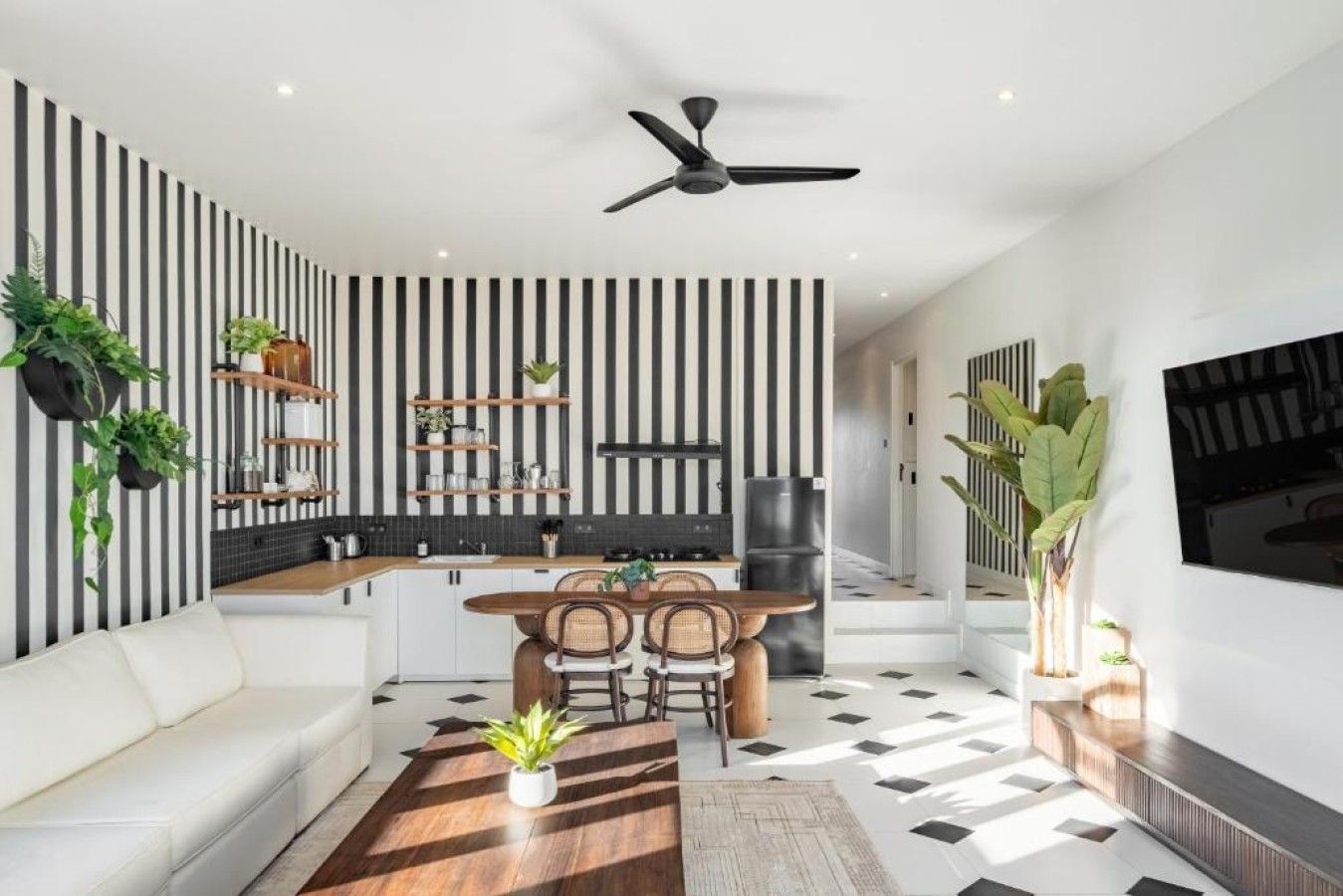 Un espace de vie moderne comprenant une cuisine, un coin repas et un espace détente.