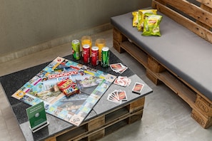 A Monopoly board game set on a table with snacks and drinks. - Cozy Studio with Pool & Gym Near Circle Mall (Dubai)