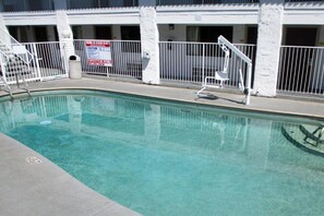 Ein Swimmingpool mit weißem Zaun und einem Warnschild.