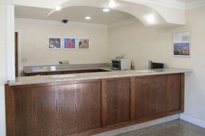 A kitchen with a wooden counter, a coffee machine, and a wall-mounted security camera. - 1 King Bed | Non-Smoking, Micfridge (Fresno CA)