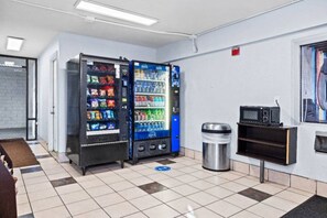 A room with vending machines, a trash can, and a microwave. - Spacious 2 Full Beds | Mini Fridge (Simi Valley)