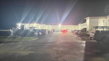 A parking lot with multiple cars and a building in the background.