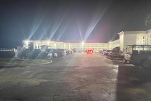 Un estacionamiento con varios automóviles y un edificio al fondo.