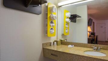 A bathroom with two sinks, a mirror, and a towel rack with multiple towels.