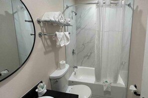 A bathroom with a toilet, sink, and bathtub.