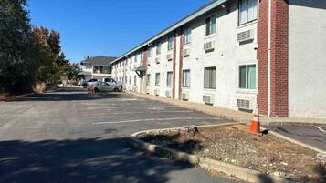 A multi-story building with a parking lot in front.