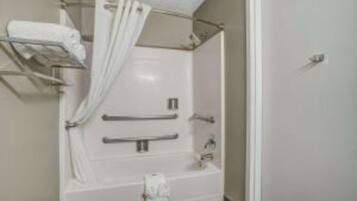 A bathroom with a bathtub, a shower, a towel rack, and a toilet.