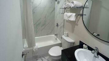 A bathroom with a bathtub, toilet, and sink.
