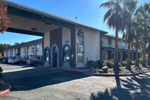 A motel with a parking lot, numbered 3444, and a covered walkway.