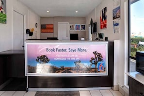 Een receptiebalie met een reclamebord voor een reisapp.
