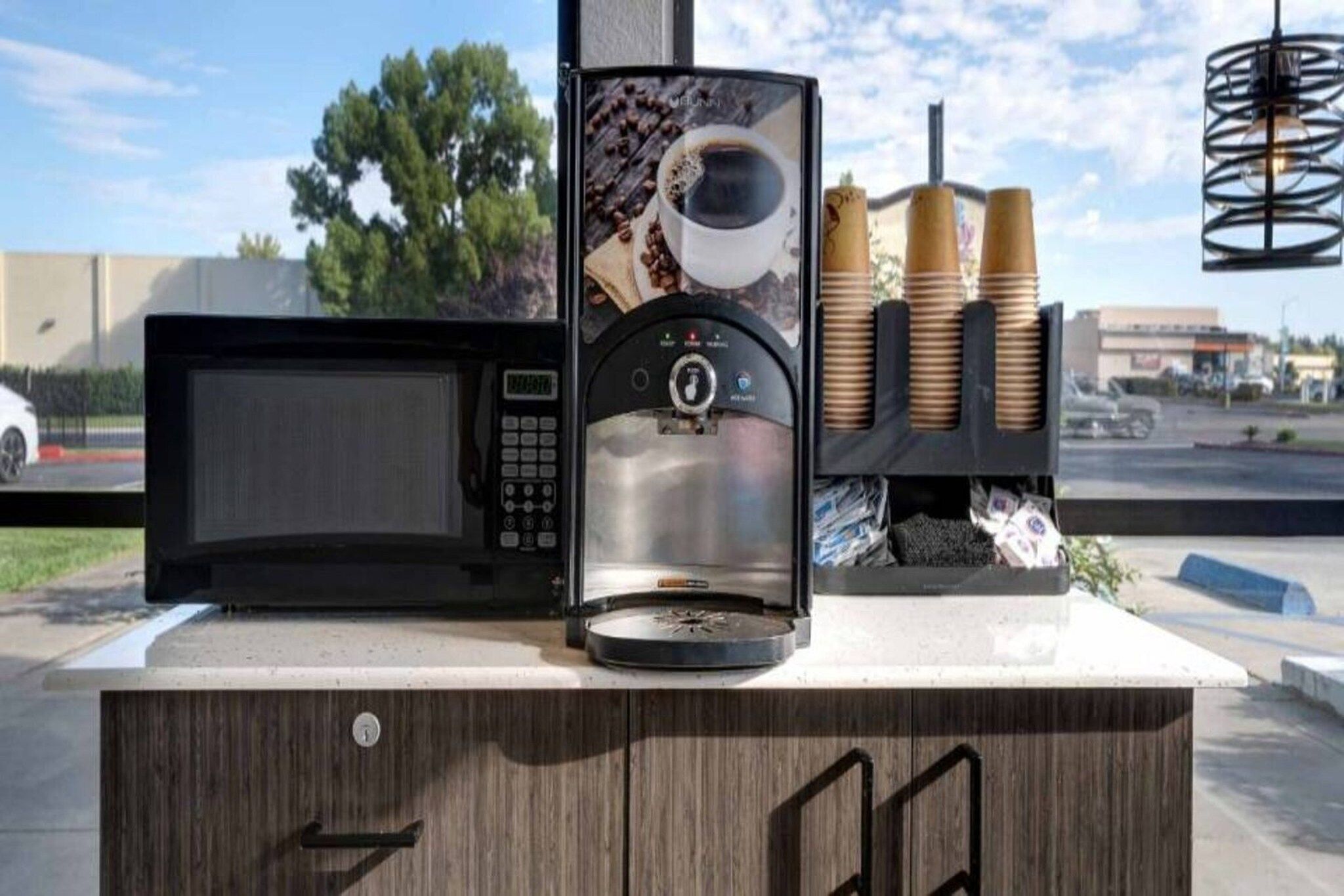 Une machine à café avec une tasse à café et des grains de café exposés.