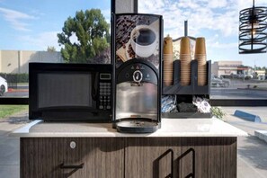 Een koffiemachine met een koffiekop en koffiebonen.