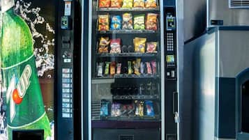 Un distributeur automatique proposant une variété de collations et de boissons gazeuses.