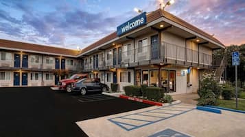 Un motel avec une enseigne « Bienvenue », un parking et une voie d’accès pour les véhicules d’urgence.