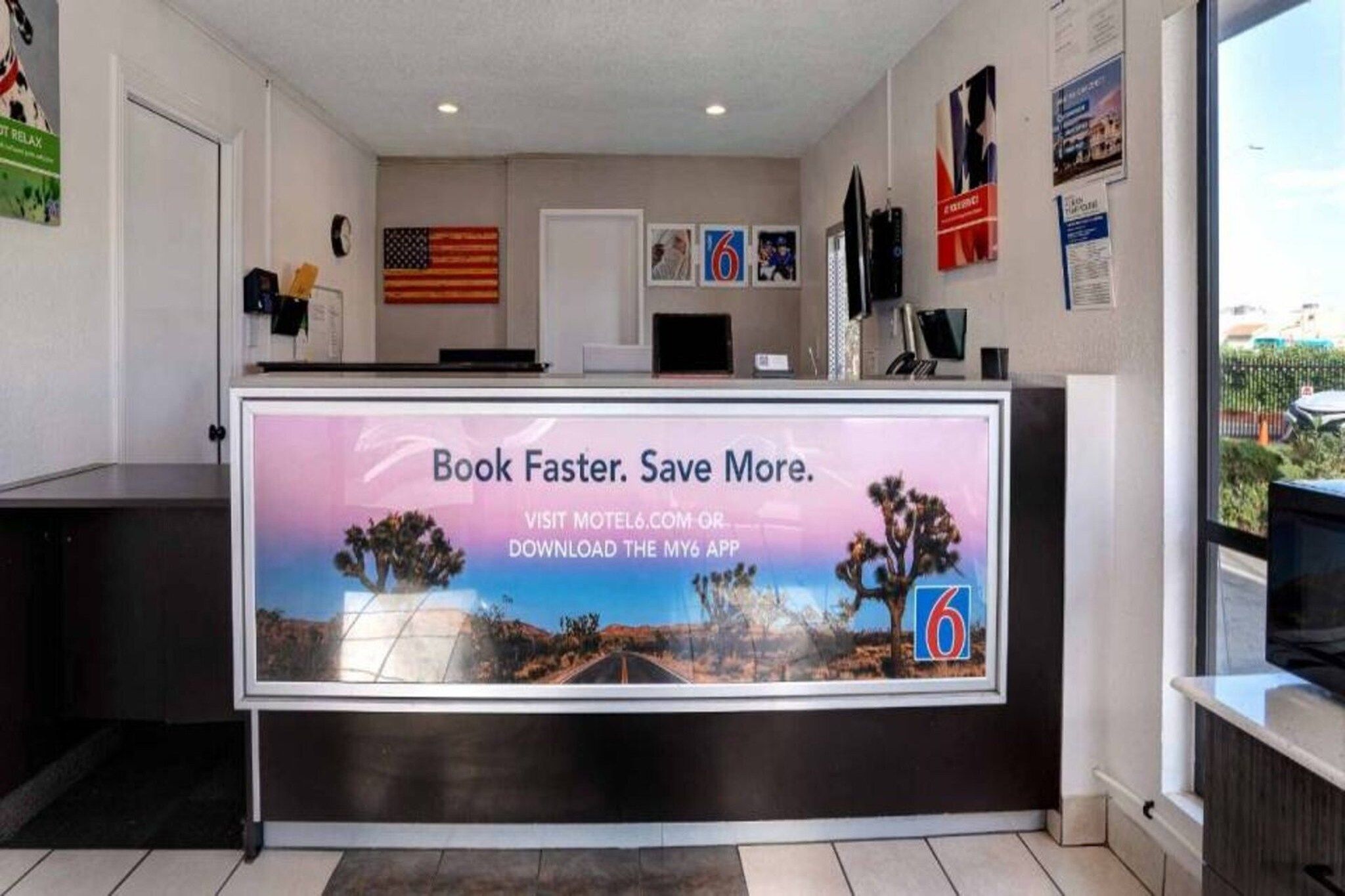 Un comptoir d’accueil avec une affiche promotionnelle pour une application de voyage.