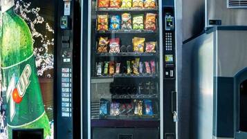 A vending machine with a variety of snack options and a soda dispenser.