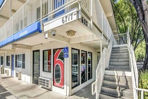 A building with a 'Welcome' sign, a large number '6' sign, and a parking sign indicating 'PARKING ONLY'. - 2 Full Beds | Non-Smoking (Stockton)