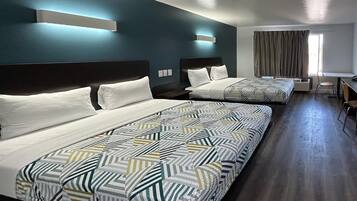 A hotel room with two beds, a desk, and a chair.