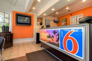 A hotel reception area with a large digital display advertising a motel.