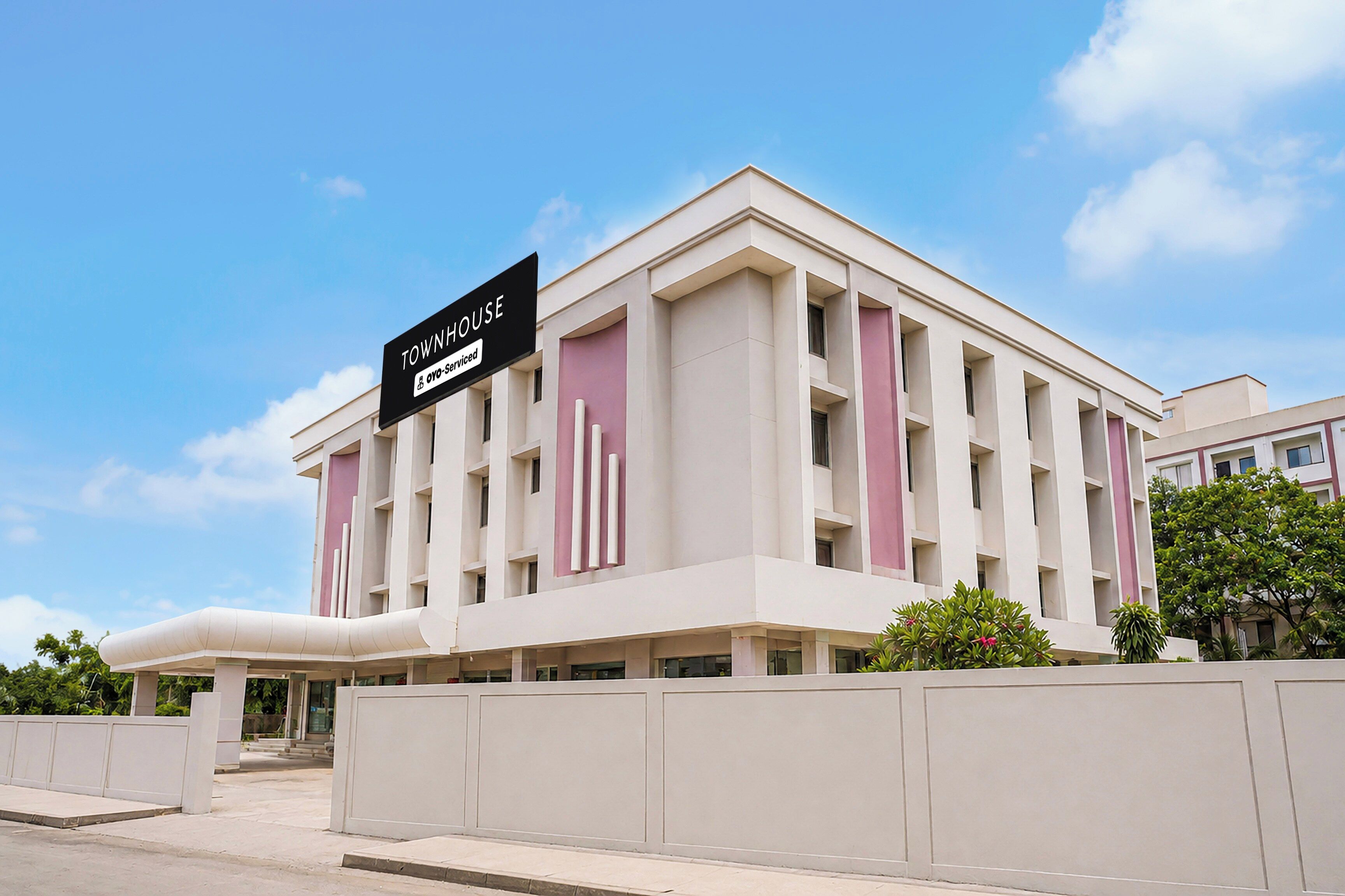 A modern building with a sign indicating it is serviced by OYO.