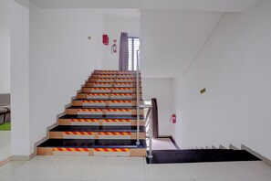 A staircase with safety railings and a fire extinguisher on the wall. - Townhouse RTO Office Silvassa (Silvassa)