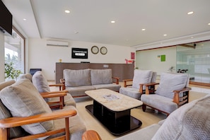 A modern reception area with a reception desk, seating area with sofas and armchairs, a clock, and a sign indicating the property name. - Townhouse RTO Office Silvassa (Silvassa)