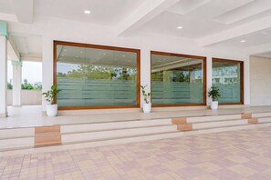A modern building entrance with glass doors, potted plants, and a tiled floor. - Townhouse RTO Office Silvassa (Silvassa)