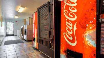 A hallway with vending machines, a refrigerator, and a microwave.