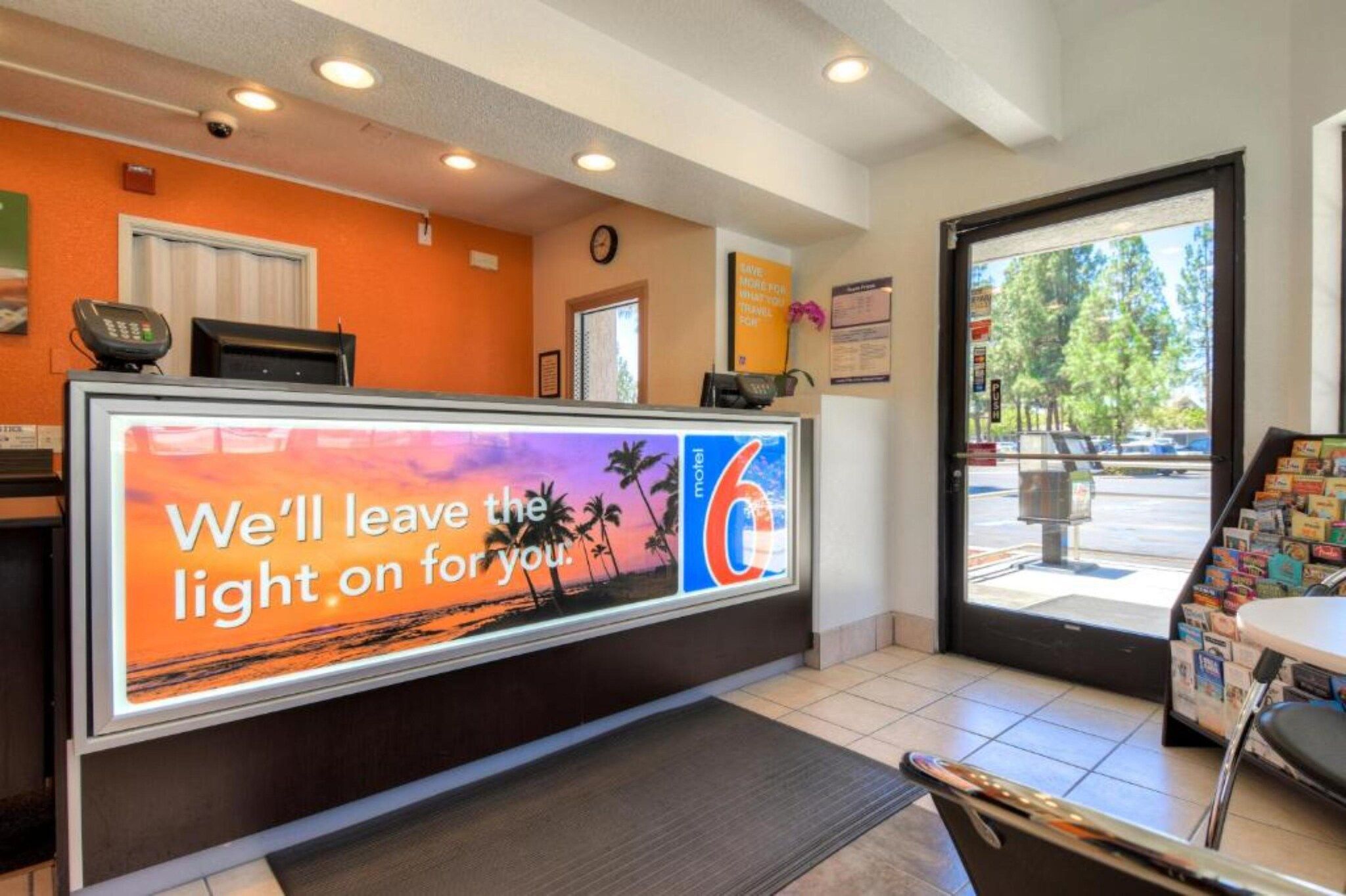 A hotel reception area with a sign that reads 'We'll leave the light on for you.'